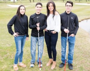 Kristin and her hildren standing on grass.  Both boys are holding their canes