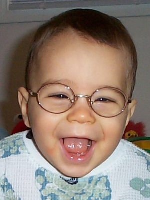 Michael as a baby, big laugh, and wearing his wire rimmed round frame glasses