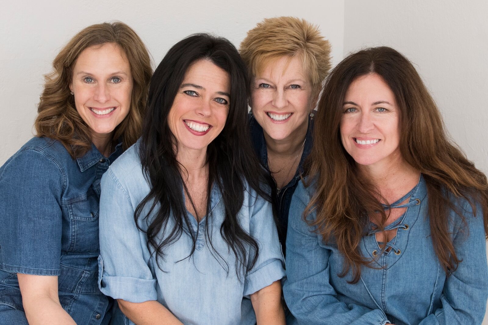 The 4 chicks sitting and smiling all in denim blue